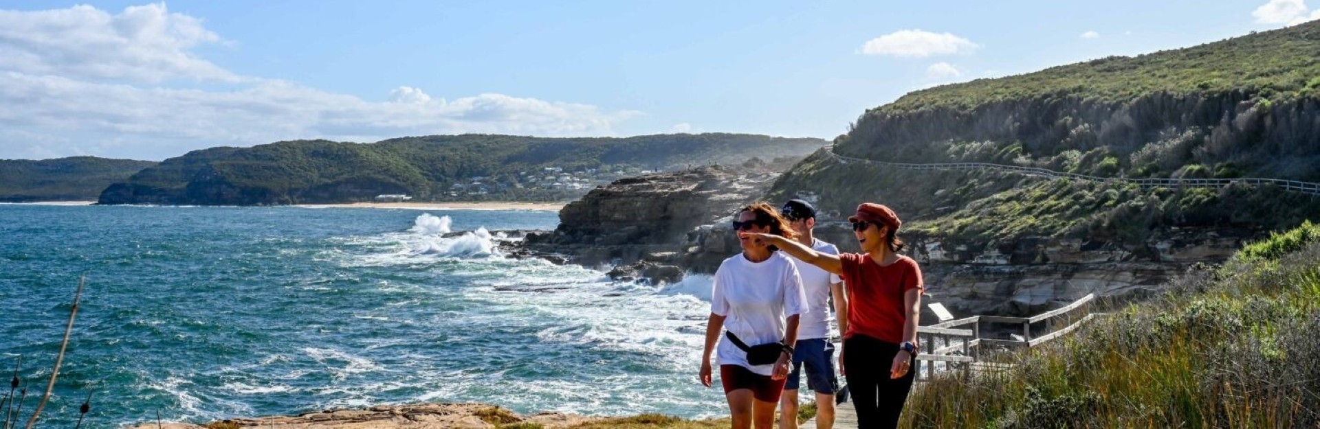 a group of 3 people hiking along the coast in the Bouddi National park