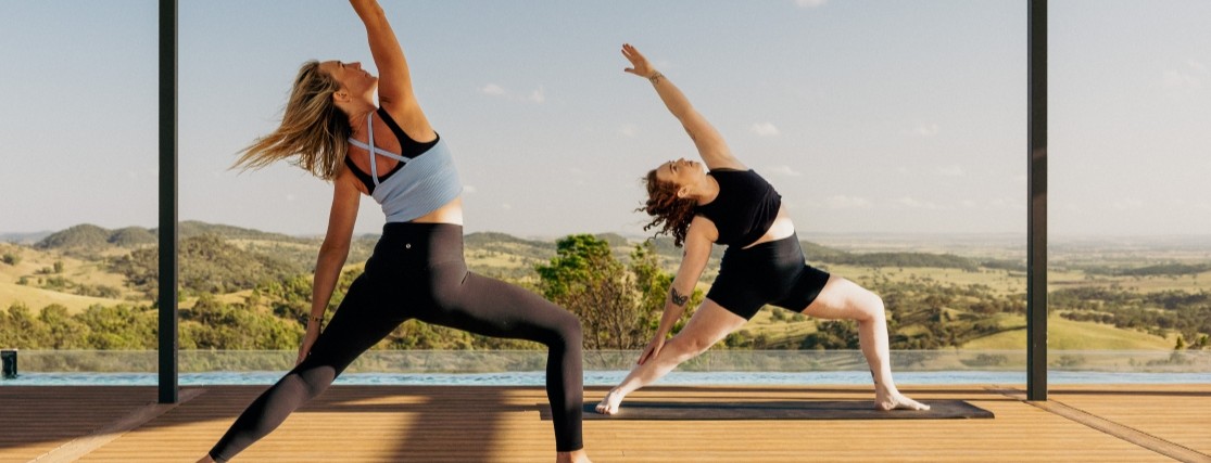 3 women practicing yoga on a deck overlooking the australian countryside in Mudgee