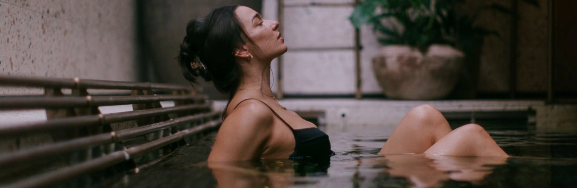 A lady in a black bikini relaxing in a bathhouse