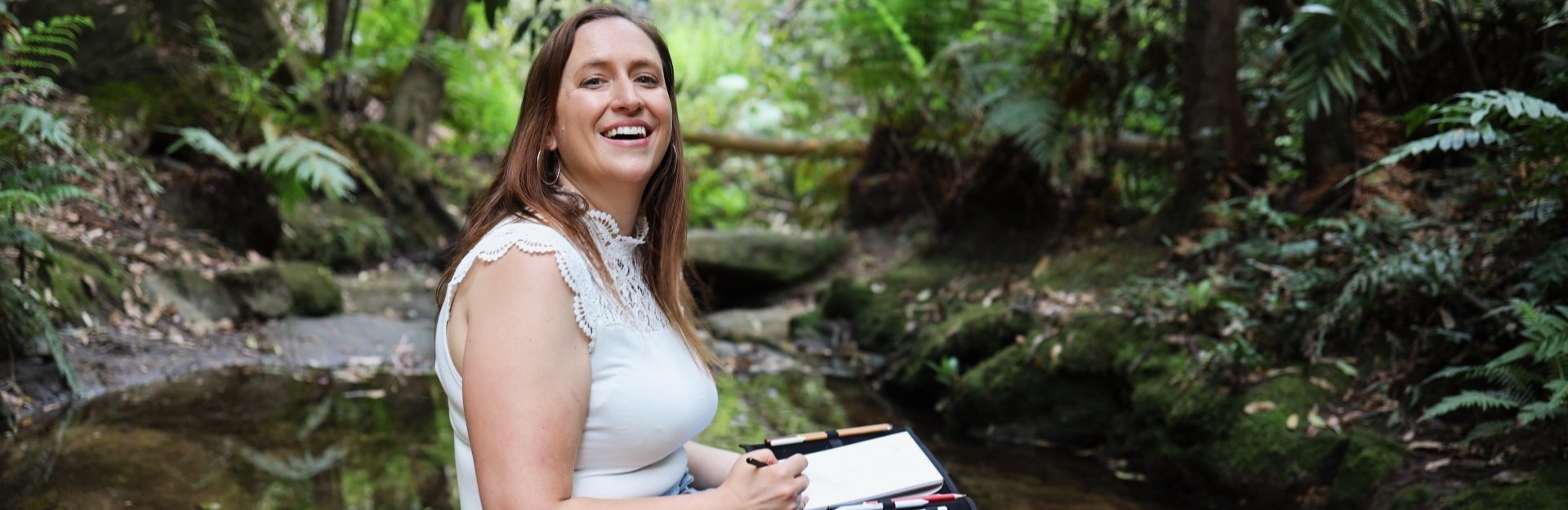 a lady sitting in a rainforest and sketching in the NSW Blue Mountains