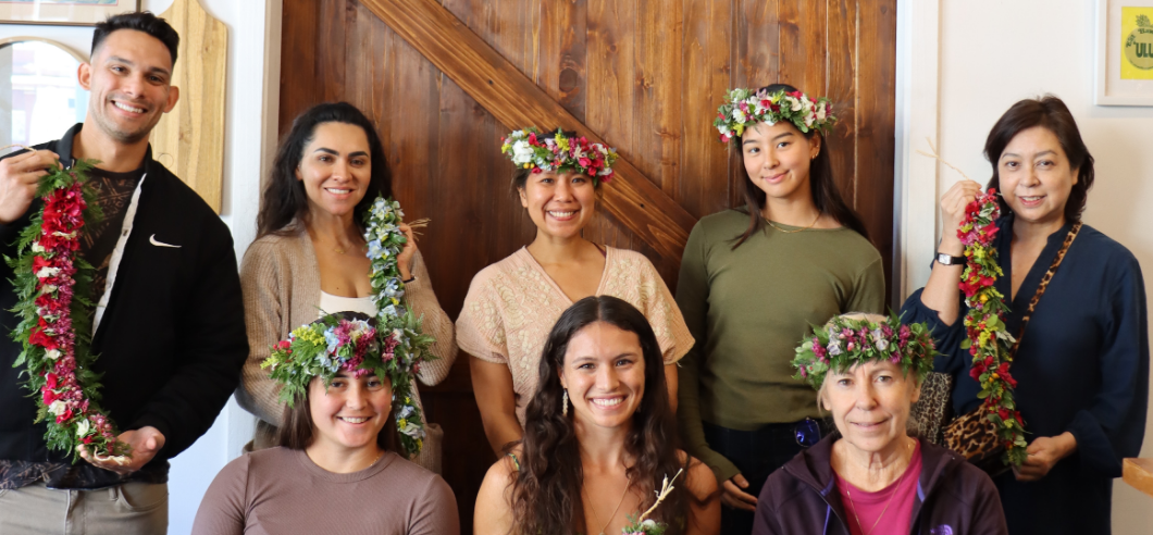 A group of people wearing traditional Hawaiian lei's that they have hand made