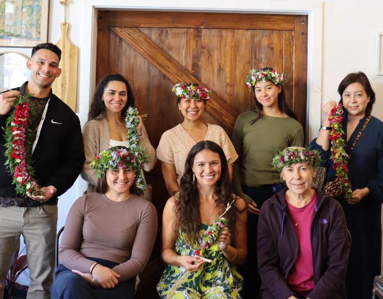 A group of people wearing traditional Hawaiian lei's that they have hand made