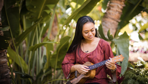 a native hawaiian woman playing the ukelele