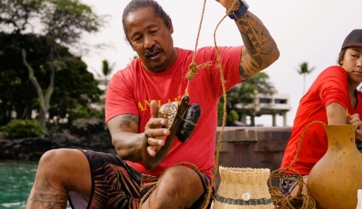 A native Hawaiian man giving a demonstration of traditional fishing