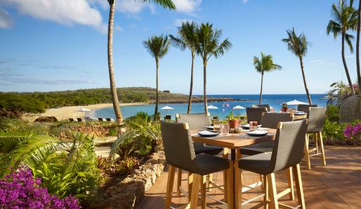a bar table and chairs overlooking the ocean from Four Seasons Resort Lanai in Hawaii