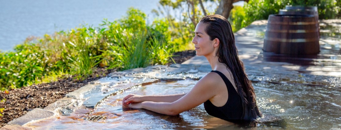 a woman bathing in a hot spring overlooking the ocean