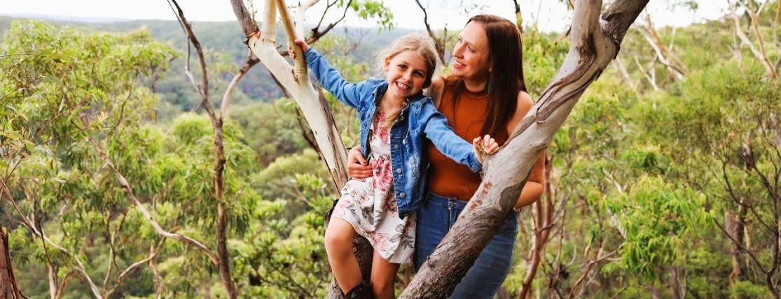 A woman and her daughter standing next to a gum tree in the NSW Blue Mountains