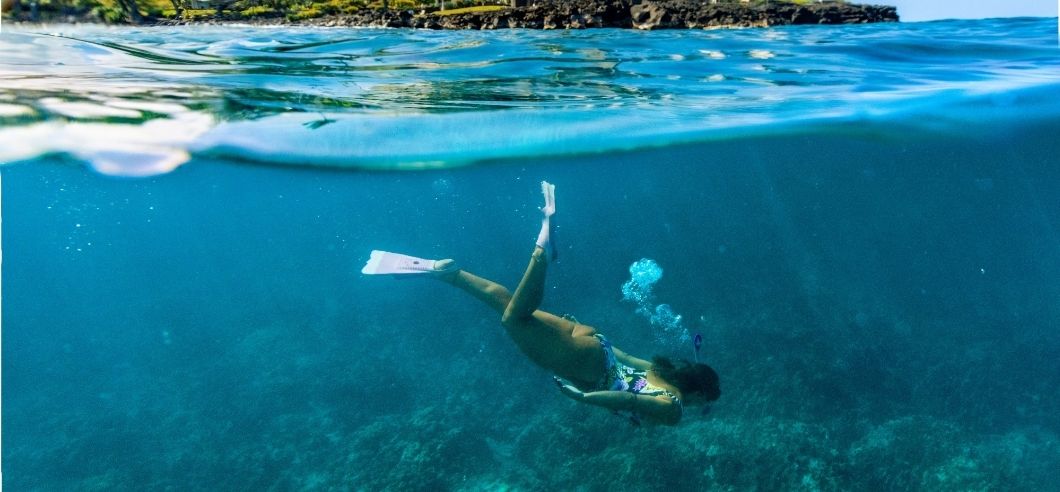 a woman snorkelling in a bay on the Kona coast of Hawaii