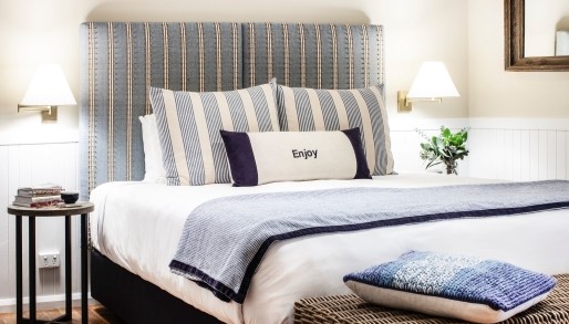 a room at Bells at Killcare, with a king bed and blue cushions