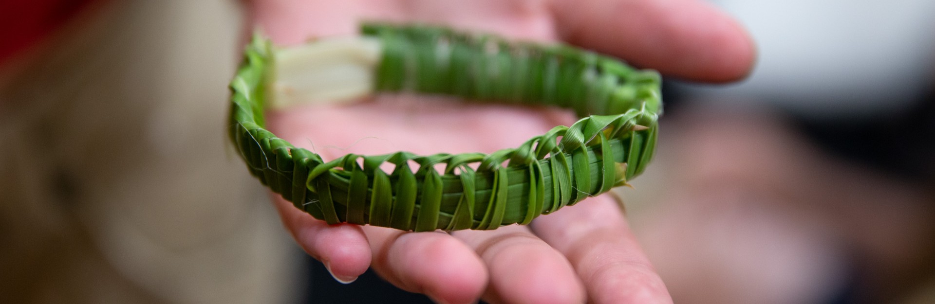a person presenting a handmade woven bracelet
