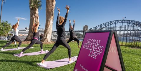 people doing yoga on the lawn in front of the Sydney Opera House