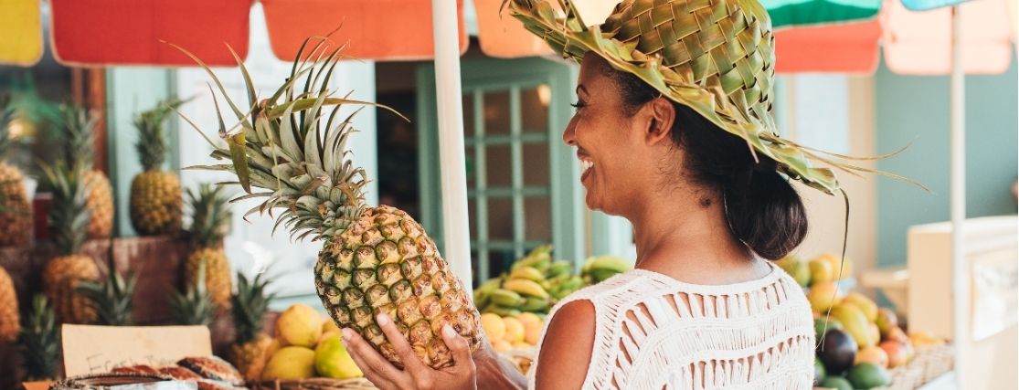 a lady buying a pineapple at a roadside stall in kauai