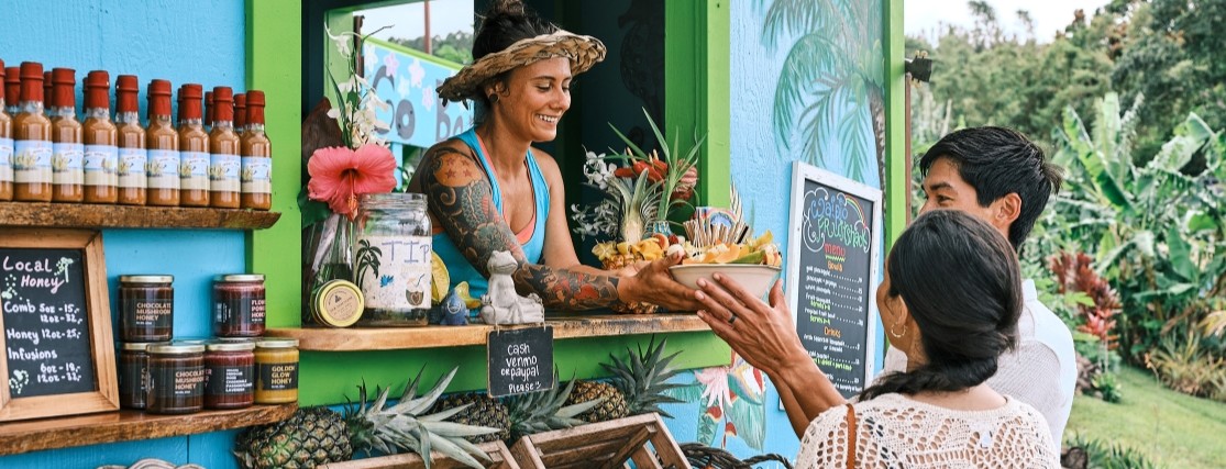 A couple purchasing food at the Waipio fruit shack on the Island of Hawai'i