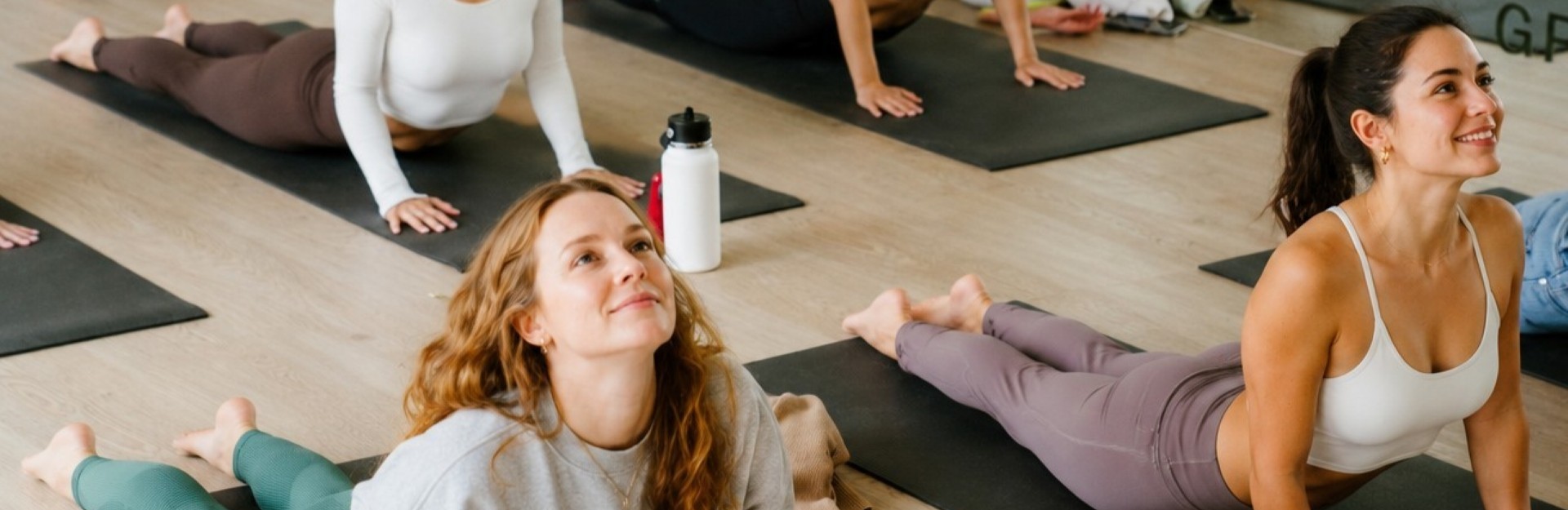 A group of ladies on yoga mats doing a cobra pose