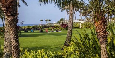 a group doing yoga on the lawn at Grand Hyatt Kauai