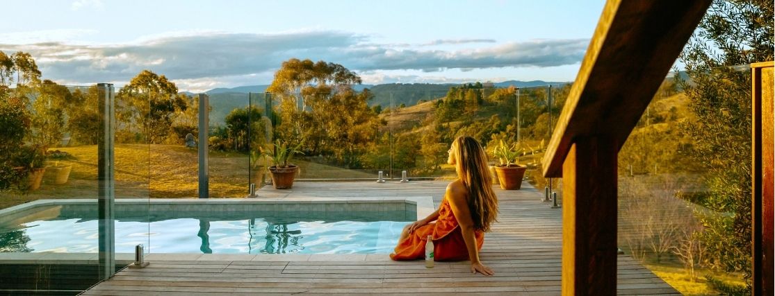 a woman sitting near a plunge pool at Mt Kanimbla Retreats