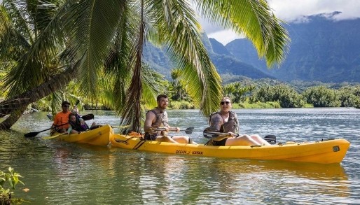 a group of kayakers paddling along the Hanalei River in Kauai