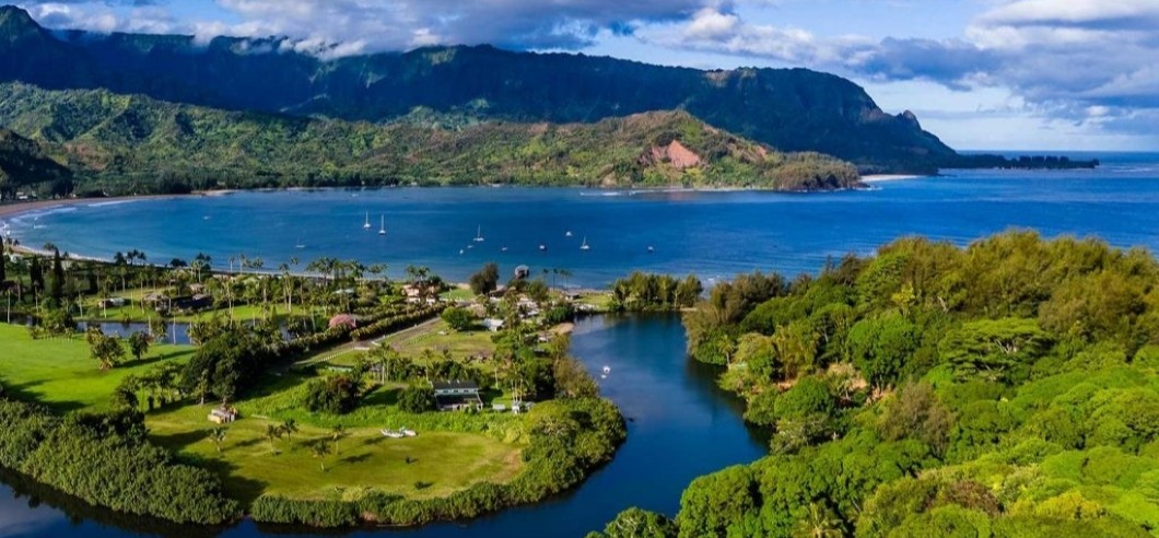 a group of kayakers paddling along the Kauai Coast in Hawaii