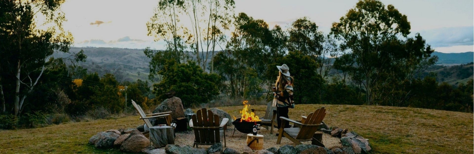 a woman near a fire pit on a paddock in the NSW Blue Mountains