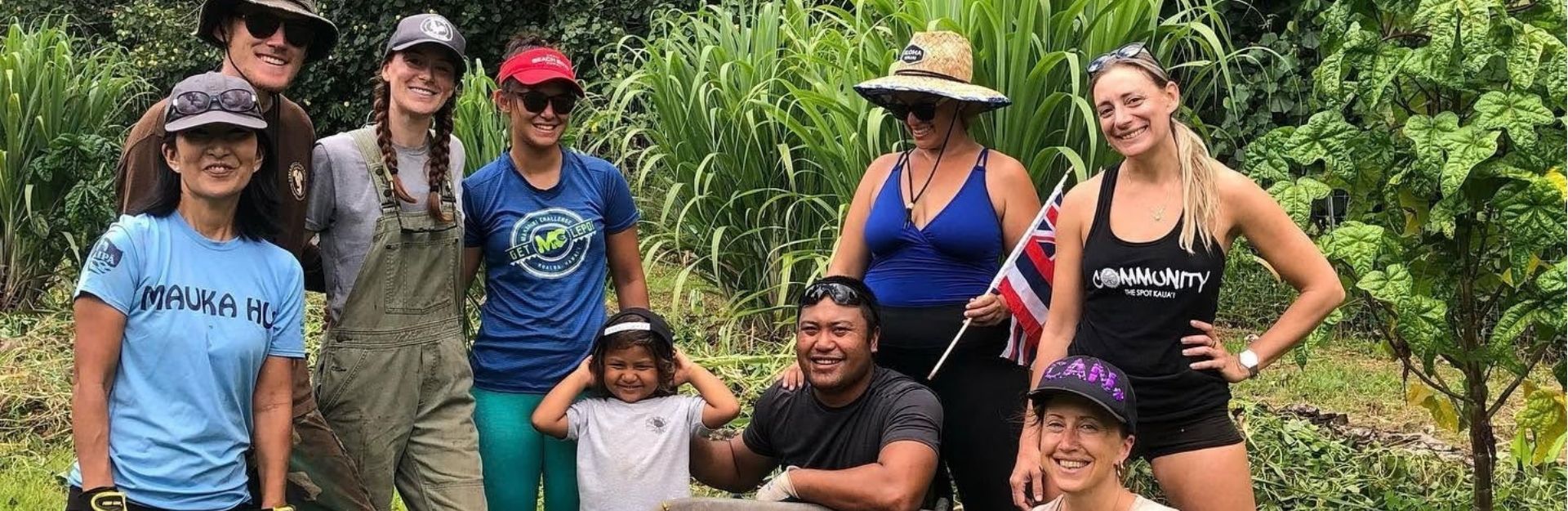 a group of people on a farm, some sitting in a wheelbarrow for the photo